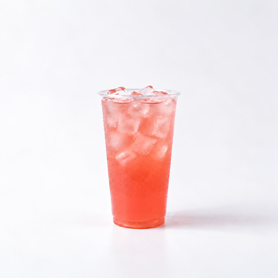 Clear plastic cup filled with an iced pink-red beverage against a white background.