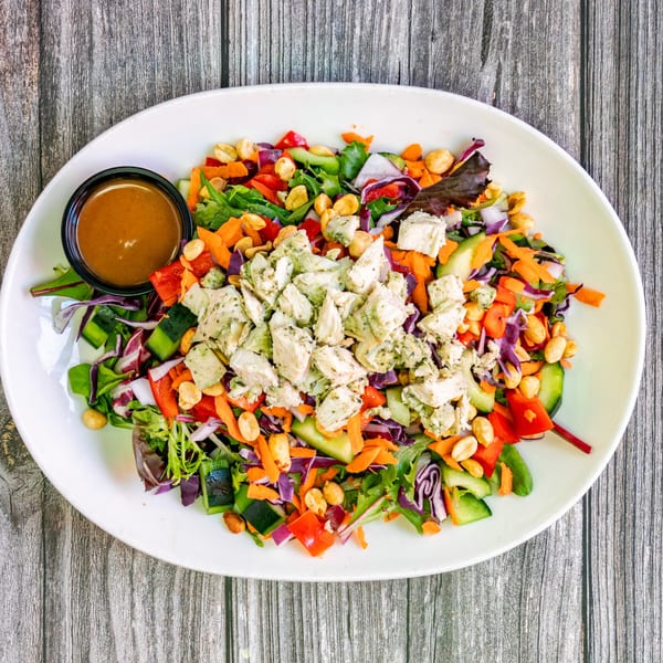 Bertha's Cafe's colorful salad with chicken, peanuts, and a side of dressing.