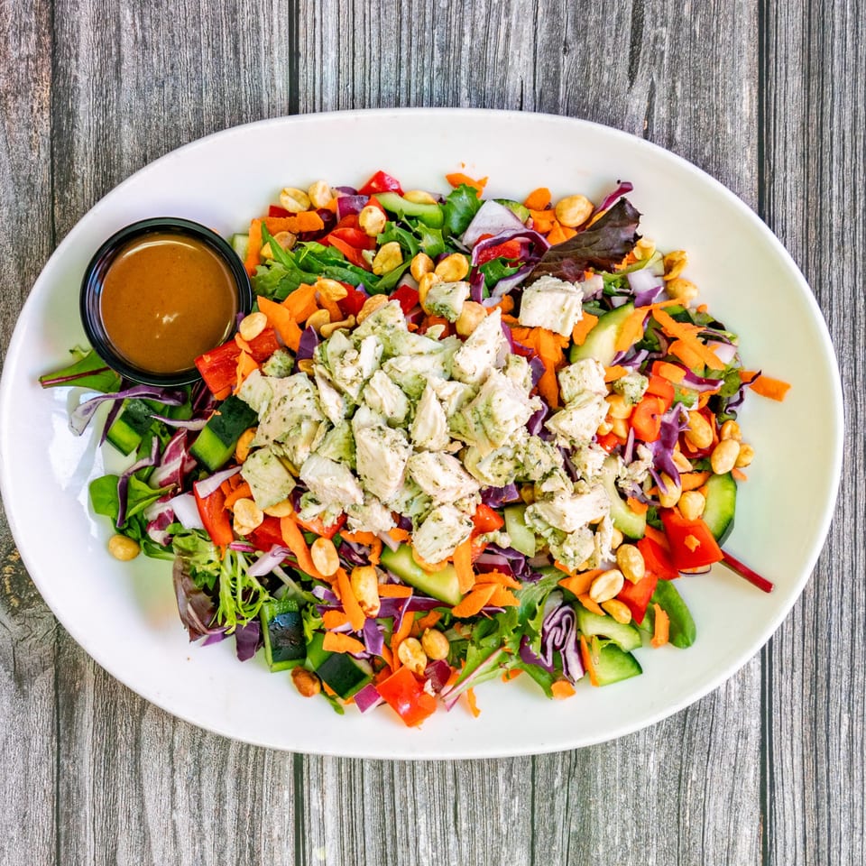 Bertha's Cafe's colorful salad with chicken, peanuts, and a side of dressing.